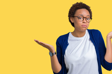 Young beautiful african american woman wearing glasses over isolated background clueless and...