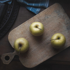 green three apples on wooden table