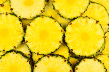 Pineapple juicy yellow slices background. Top view.