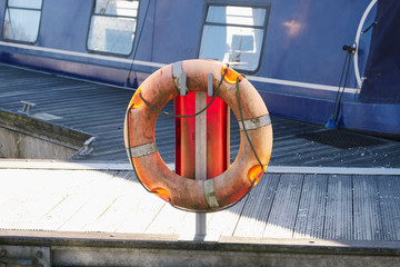 Life buoy orange ring water safety at boat mooring marina