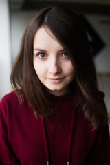 big eyes, sweet girl in burgundy hoodie, smiling and looking at you