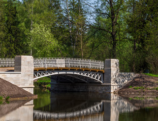 Fototapeta na wymiar Stone bridge over the river in the park
