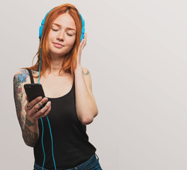 portrait of a pretty redhead girl listening to music