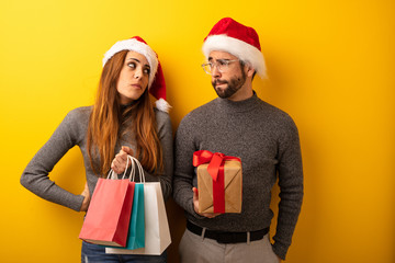 Couple or friends holding gifts and shopping bags thinking about an idea