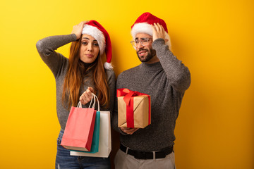 Couple or friends holding gifts and shopping bags worried and overwhelmed
