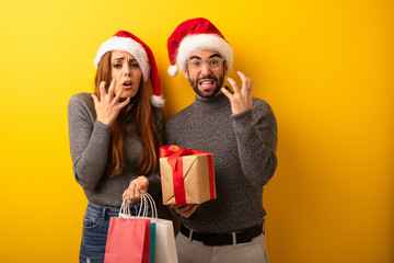 Couple or friends holding gifts and shopping bags very scared and afraid