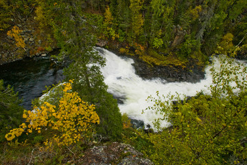 Cliff, stone wall, forest, waterfall and wild river panoramic view in autumn. Fall colors - ruska time in Myllykoski. Karhunkierros Trail, Oulanka National Park in north Finland. Lapland, Europe