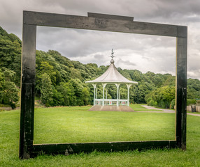 gazebo or band stand framed in a wooden black frame. 