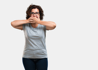 Middle aged woman covering mouth, symbol of silence and repression, trying not to say anything