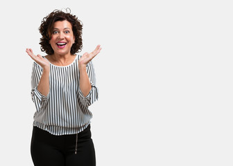 Middle aged woman surprised and shocked, looking with wide eyes, excited by an offer or by a new...