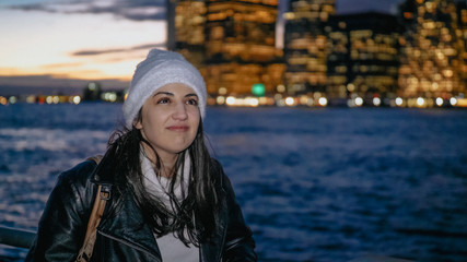 Young woman enjoys the fantastic view over the Manhattan skyline by night