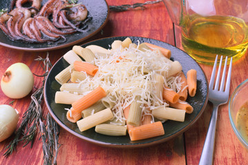 plate of colored macaroni with cheese on veined red wood