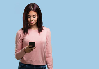 Fototapeta premium Young pretty woman closeup of hand touching a mobile, using internet and social networks, positive feeling of future and modernity