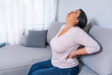 Senior woman suffering from backache at home