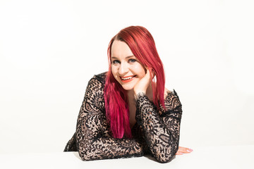 Beautiful woman with red long hair wearing a lacy dress. Beauty portrait of modern fashion, white background.