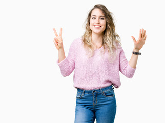Beautiful young blonde woman over isolated background showing and pointing up with fingers number seven while smiling confident and happy.