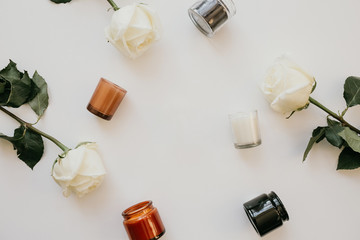 Composition of white roses and candles in cans on a white background. Flat lay, top view, copy space