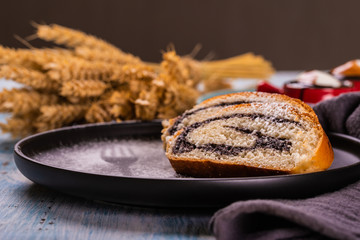 Poppy seed strudel on dark plate with silhouette of fork made by sugar