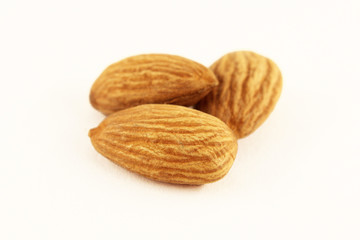 Closeup of almonds. Three almond nuts on a white background