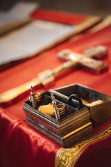 Christening in the church, golden religious utensils: bible, cross, prayer book, missal. Details in the orthodox christian church