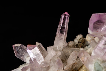 Macro mineral stone Amethyst crystals in rock on a black background