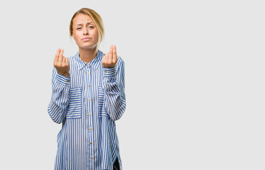 Portrait of a young pretty blonde woman sad and depressed, making a gesture of need, restoring to...