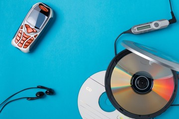 personal cd player with remote control and mobile phone on blue background