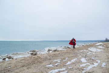 Young woman walks at the winter beach.