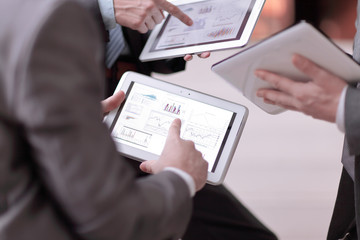 close up.businessmens discuss schedule of sales through the tab