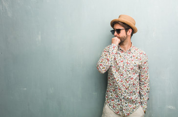 Young traveler man wearing a colorful shirt biting nails, nervous and very anxious and scared for the future, feels panic and stress