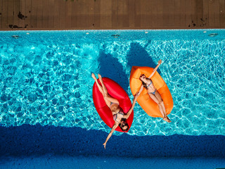 Two girls are swimming in the pool