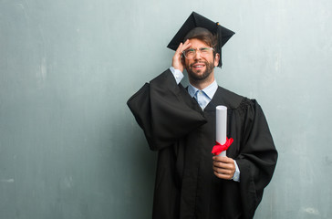 Young graduated man against a grunge wall with a copy space frustrated and desperate, angry and sad with hands on head