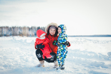 Fototapeta na wymiar Mom daughter and son hugging for a walk on a cool winter day
