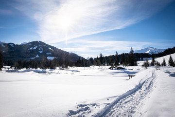 Fototapeta na wymiar Snow covered frozen lake in holiday-resort Hohentauern on winter day