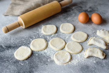 Fototapeta na wymiar Preparation dough and production of circles from dough for preparation of dumplings with a stuffing. It can be used as a background