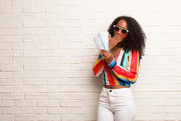 Young black woman covering mouth, symbol of silence and repression, trying not to say anything