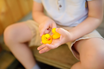 Little boy playing with family of rubber duck