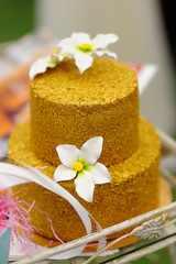 Fototapeta na wymiar Gold wedding cake decorated with white sugar flowers.