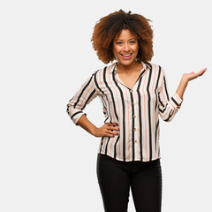 Young black afro woman holding something with hand
