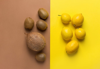 Bunch of raw organic lemons kiwi coconut on duotone yellow brown background. Creative flat lay food poster. Vegan vitamins summer tropical fruits cocktail ingredients. Copy space