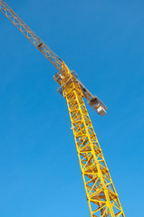 Construction crane against the blue sky with clouds. Construction site. Building construction