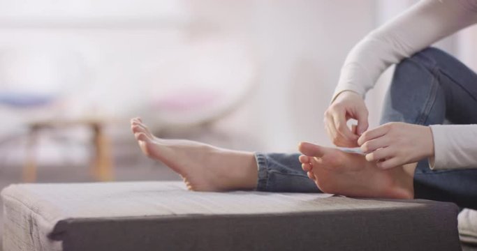 Young caucasian girl tending to her hurting foot