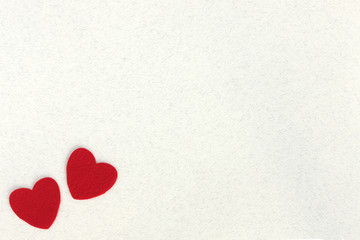 Fototapeta premium red felt hearts on white paper background with space for text