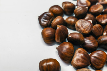 Chestnuts on a blank (white) background. Pile of fresh chestnuts ready to roast shot over white background