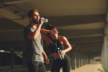 Young couple resting after jogging in the urban environment