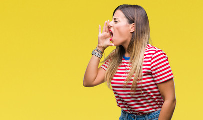 Young beautiful woman casual look over isolated background shouting and screaming loud to side with hand on mouth. Communication concept.