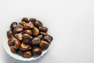 Chestnuts on a blank (white) background. Pile of fresh chestnuts ready to roast shot over white background