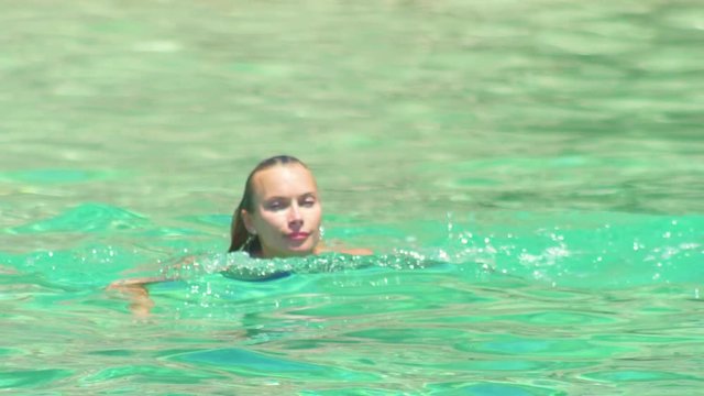 Beautiful woman swimming in the amazing water of the sea in Ibiza beach