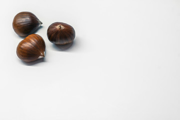Chestnuts on a blank (white) background. Pile of fresh chestnuts ready to roast shot over white background
