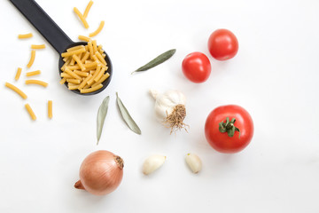 Pasta with tomatoes garlic and onion isolated on white background. Top view.